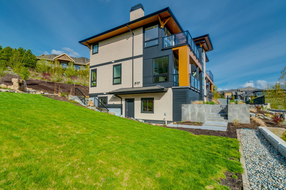 Großes, Dreistöckiges Modernes Einfamilienhaus mit Putzfassade, brauner Fassadenfarbe, Flachdach und Ziegeldach in Vancouver