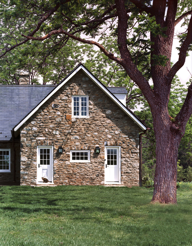 Réalisation d'une façade de maison beige champêtre en pierre de taille moyenne et à deux étages et plus avec un toit à deux pans et un toit en shingle.