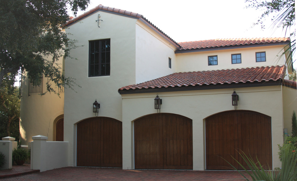 Photo of a large and beige mediterranean two floor render house exterior in Orlando with a half-hip roof.