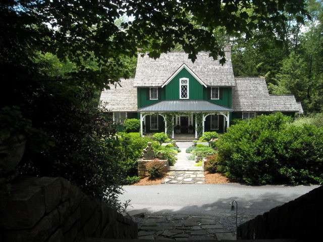 Photo of a green country two floor house exterior in Charlotte with wood cladding.