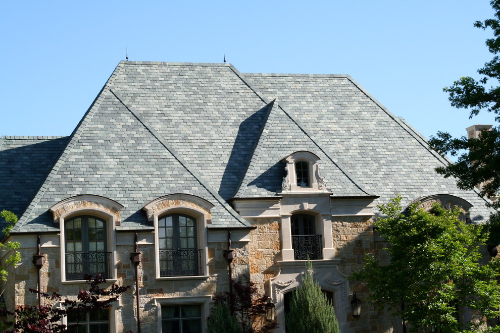 Inspiration for a large and beige classic two floor house exterior in Dallas with stone cladding and a hip roof.