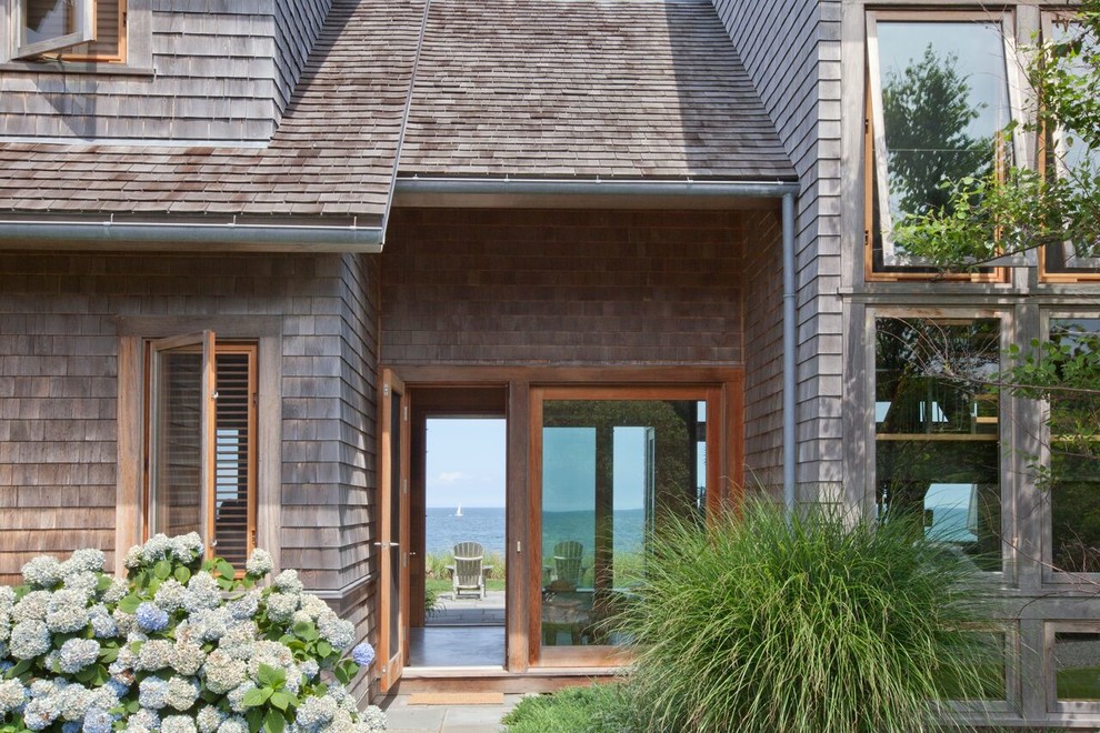 Inspiration for a large coastal brown two-story wood exterior home remodel in Boston with a shed roof