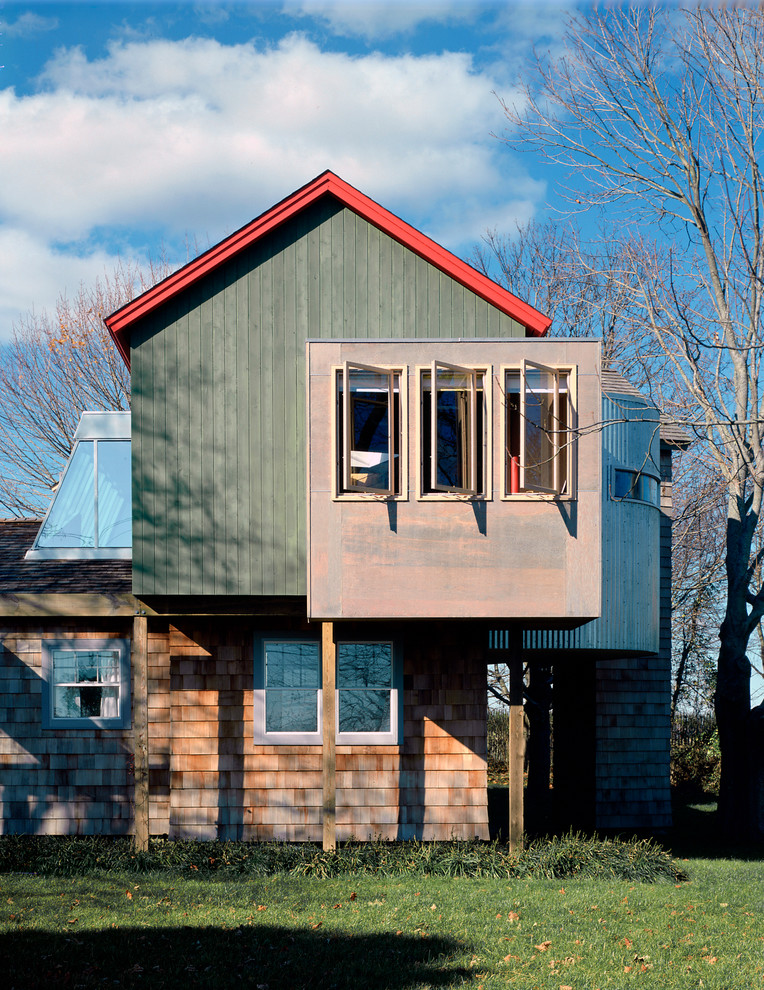 This is an example of a medium sized and multi-coloured contemporary two floor house exterior in New York with mixed cladding and a pitched roof.