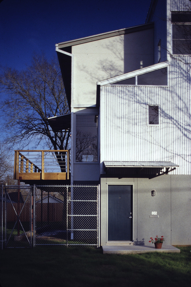 Imagen de fachada gris industrial grande de tres plantas con revestimiento de metal y tejado de un solo tendido