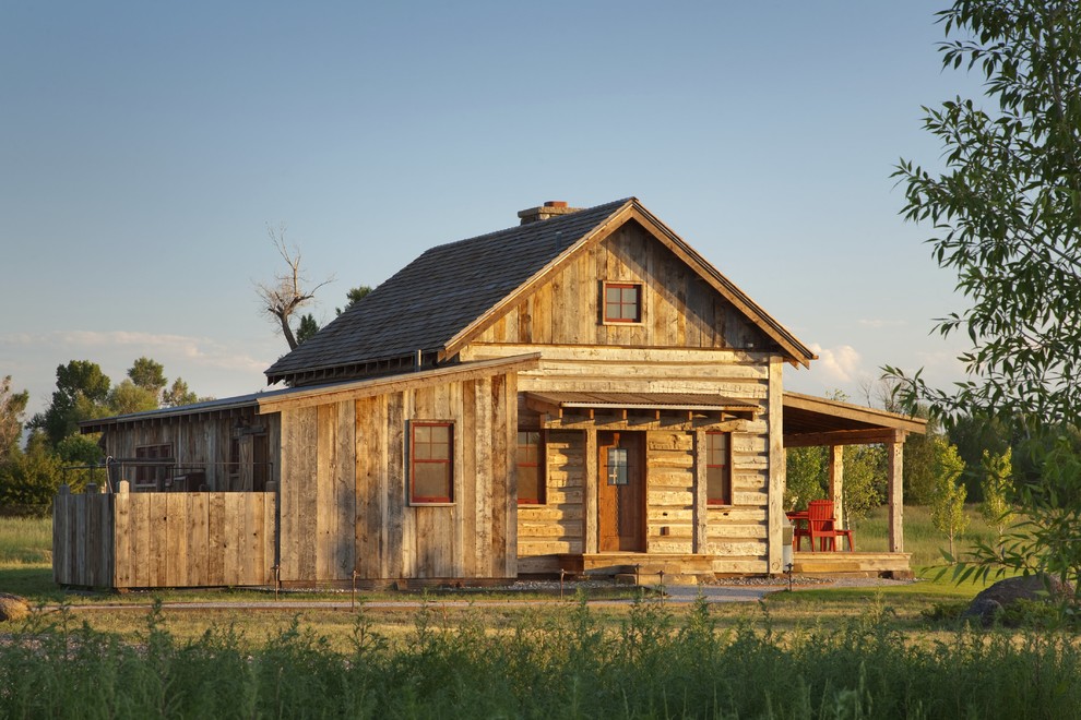 Photo of a rustic detached house in Other with wood cladding.