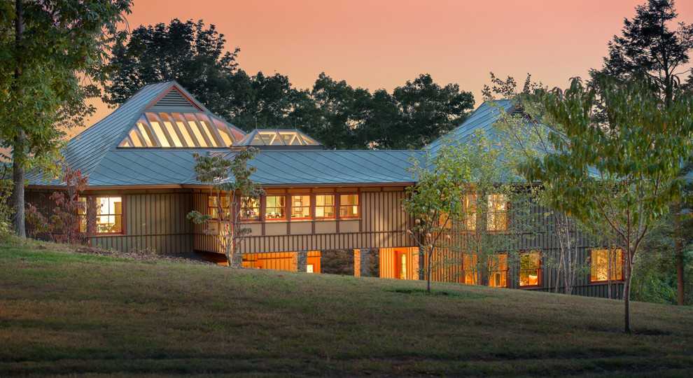 Inspiration för ett stort funkis grönt hus, med tre eller fler plan, fiberplattor i betong, valmat tak och tak i metall