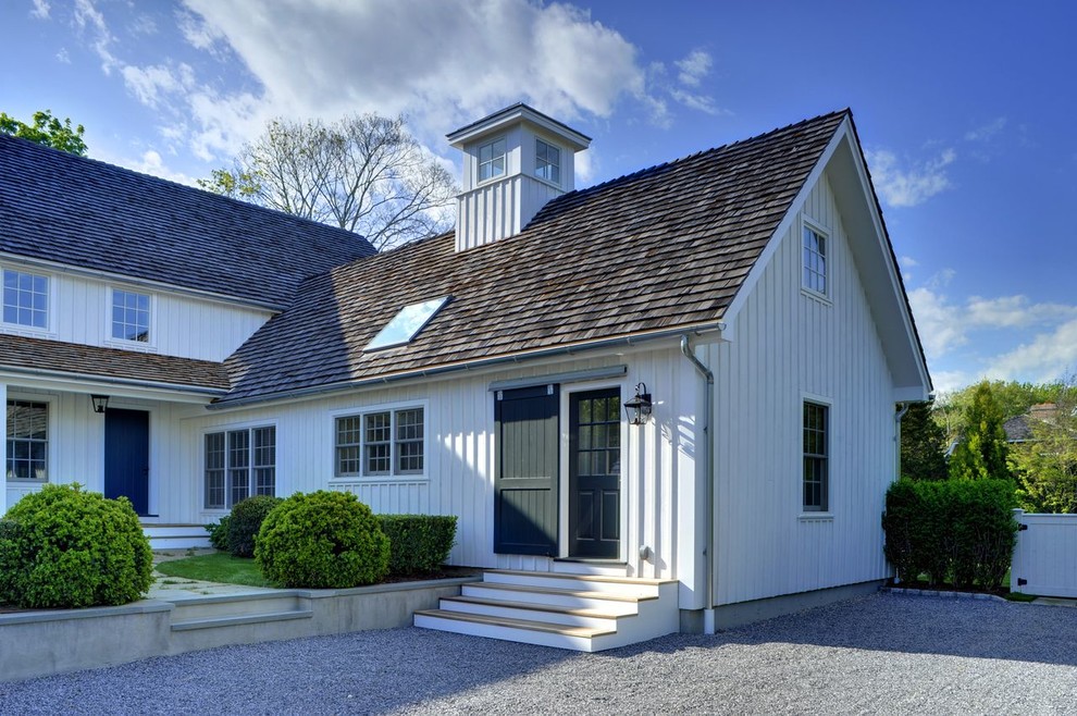 Large and white traditional two floor house exterior in New York with wood cladding and a pitched roof.