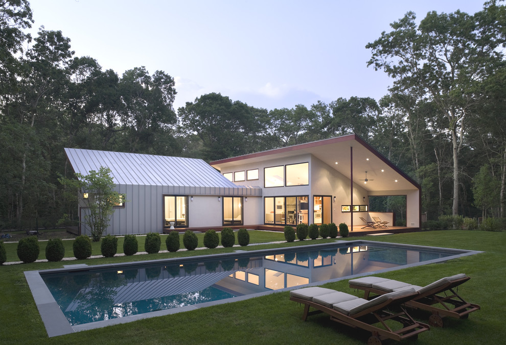 Exemple d'une façade de maison métallique et beige tendance de taille moyenne et de plain-pied avec un toit en appentis.