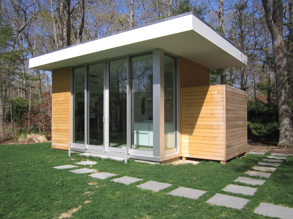Photo of a gey modern bungalow house exterior in New York with wood cladding.