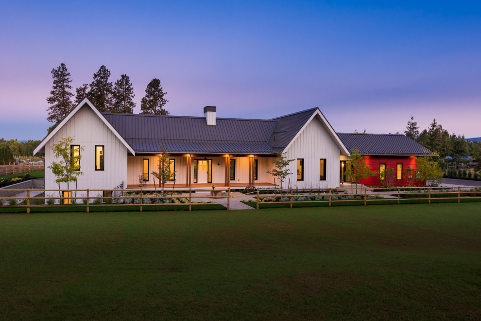 Immagine della villa bianca country a un piano con tetto a capanna, copertura in metallo o lamiera, tetto grigio e pannelli e listelle di legno