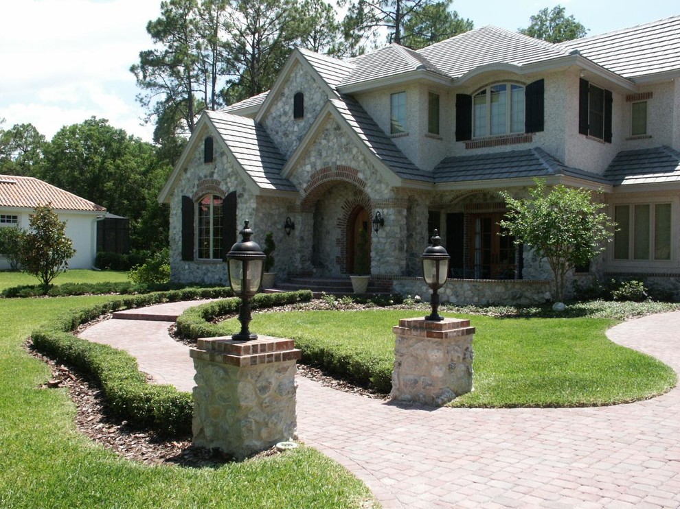 Foto de fachada de casa gris tradicional grande de dos plantas con revestimientos combinados, tejado a cuatro aguas y tejado de teja de barro