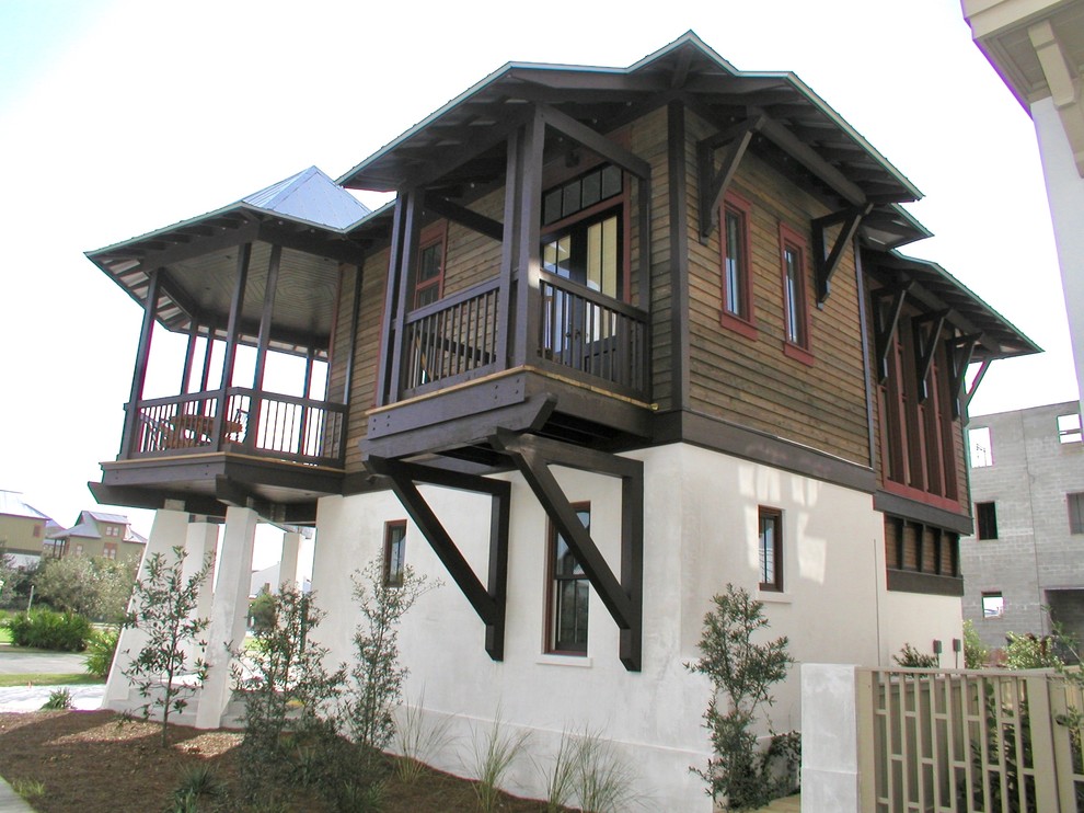Cette image montre une façade de maison multicolore ethnique en bois de taille moyenne et à un étage avec un toit à quatre pans et un toit en métal.