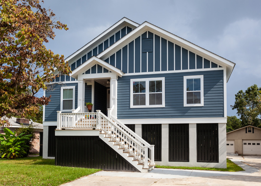 Modelo de fachada de casa azul costera de tamaño medio de dos plantas con revestimiento de madera, tejado a dos aguas y tejado de teja de madera