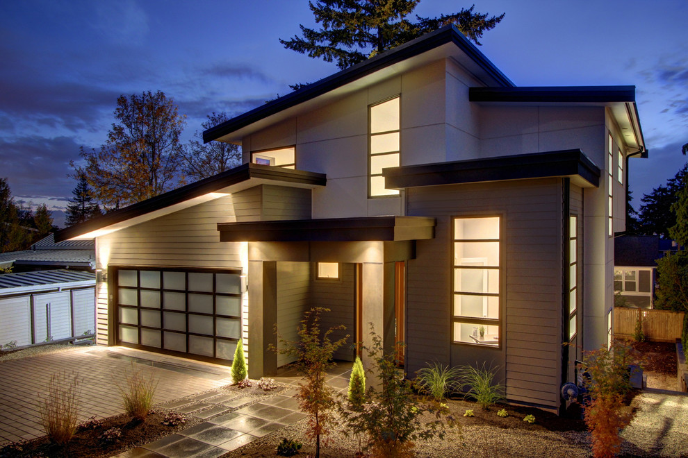 На фото: большой, двухэтажный, деревянный, серый дом в современном стиле с плоской крышей с
