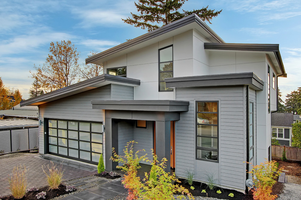 Photo of a large and gey contemporary two floor house exterior in Seattle with wood cladding and a flat roof.