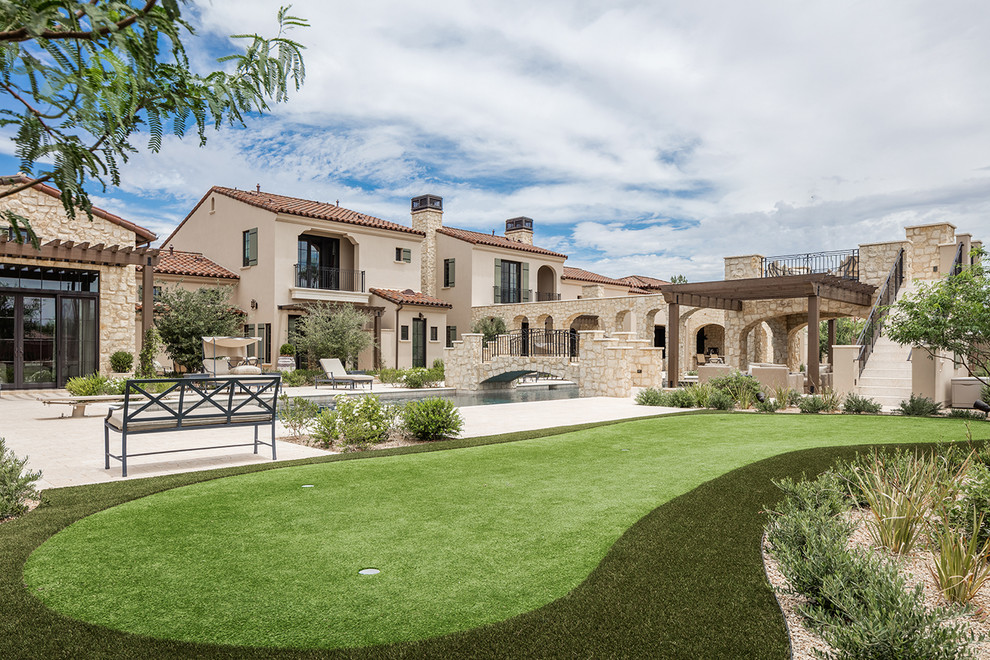 Diseño de fachada de casa beige mediterránea grande de dos plantas con revestimiento de estuco, tejado a dos aguas y tejado de teja de barro