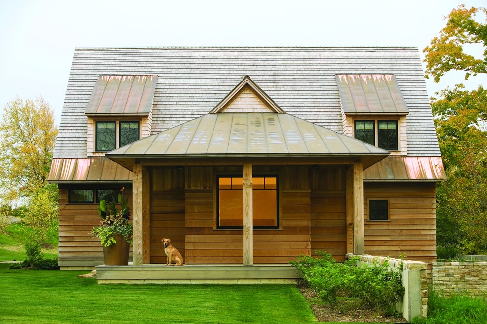 Aménagement d'une façade de maison montagne en bois de taille moyenne et à un étage avec un toit mixte.