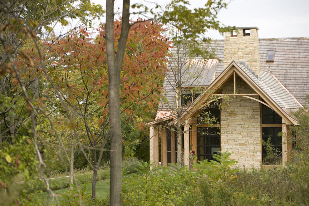 Imagen de fachada beige rural de dos plantas con tejado a dos aguas y revestimiento de madera