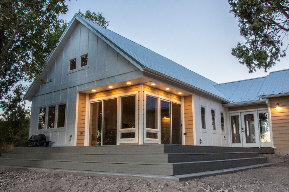 Modelo de fachada beige de estilo de casa de campo de tamaño medio de una planta con tejado a dos aguas y revestimiento de madera