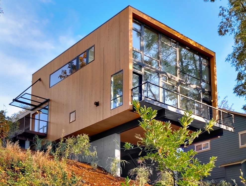 Modelo de fachada marrón minimalista de tamaño medio de dos plantas con revestimiento de madera y tejado plano