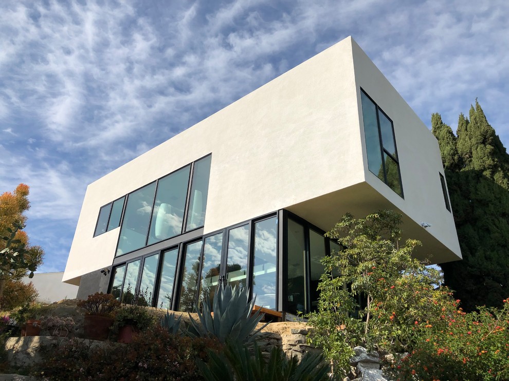 Mittelgroßes, Zweistöckiges Modernes Einfamilienhaus mit Putzfassade, beiger Fassadenfarbe, Flachdach und Wandpaneelen in Los Angeles