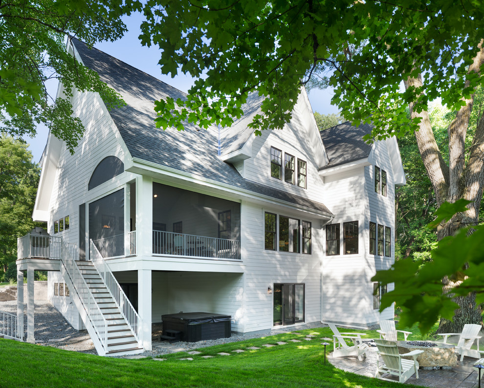 Стильный дизайн: огромный, трехэтажный, белый частный загородный дом в стиле неоклассика (современная классика) с облицовкой из ЦСП, двускатной крышей и крышей из гибкой черепицы - последний тренд