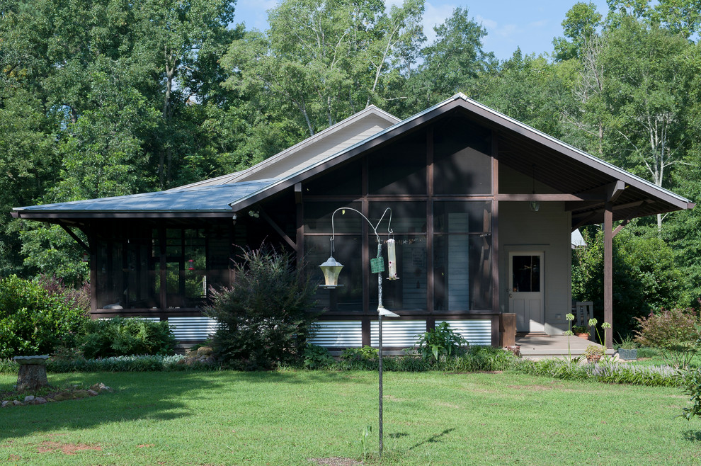 Aménagement d'une façade de maison verte éclectique en bois de taille moyenne et à un étage avec un toit à deux pans et un toit en métal.