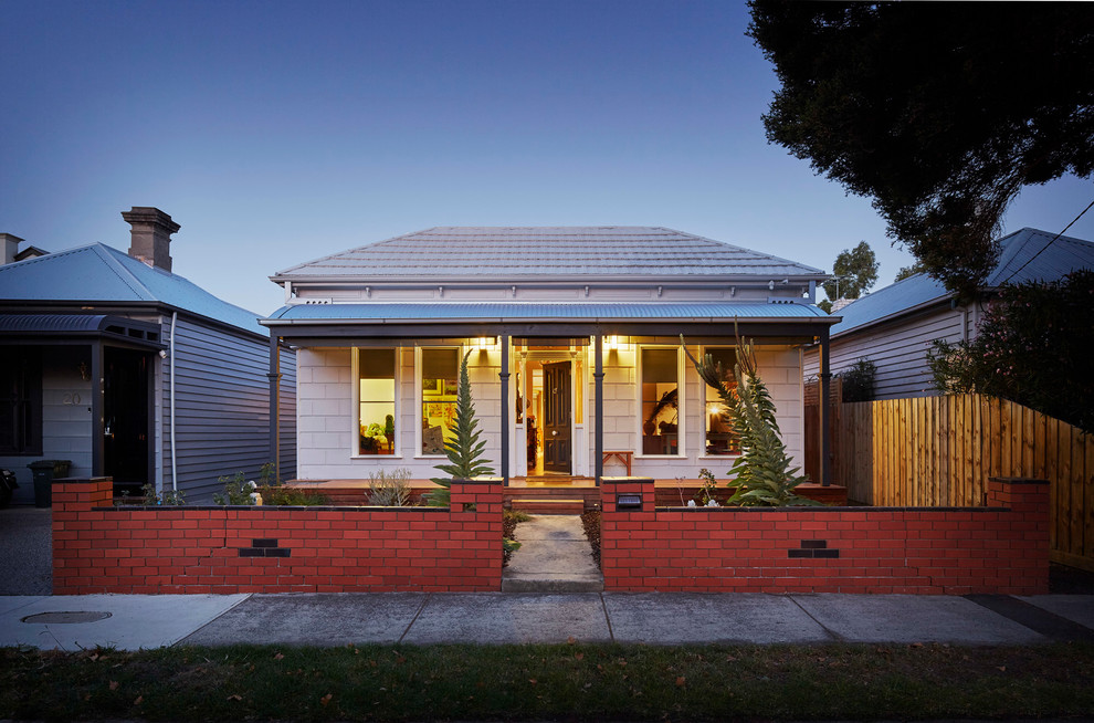 Medium sized and white traditional bungalow house exterior in Melbourne with wood cladding and a hip roof.