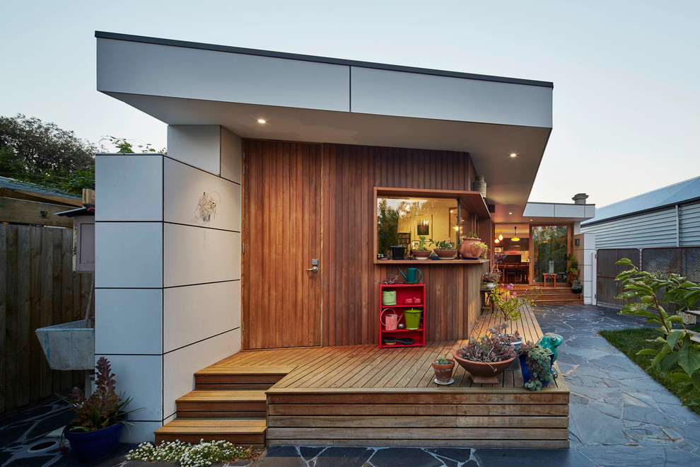 Aménagement d'une façade de maison marron contemporaine en bois de taille moyenne et de plain-pied avec un toit plat.