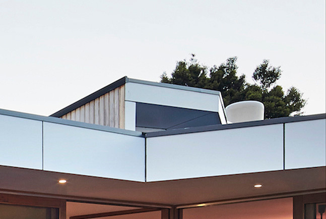 Cette image montre une façade de maison marron design en bois de taille moyenne et de plain-pied avec un toit à quatre pans.