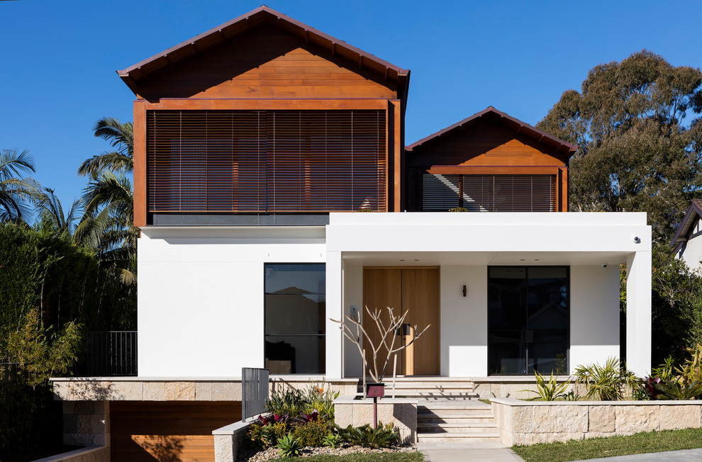 Cette image montre une façade de maison multicolore design à un étage avec un revêtement mixte et un toit à deux pans.