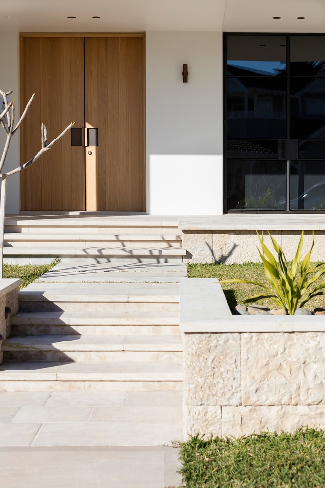 Imagen de fachada de casa contemporánea de dos plantas con revestimiento de piedra