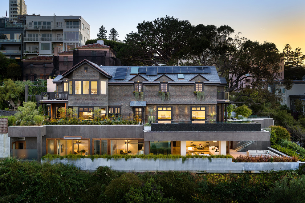 Cette image montre une grande façade de maison grise design à deux étages et plus avec un revêtement mixte, un toit à deux pans et un toit en shingle.