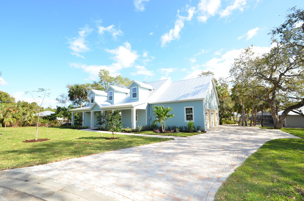 Mittelgroßes, Zweistöckiges Einfamilienhaus mit Vinylfassade, blauer Fassadenfarbe, Walmdach und Blechdach in Miami