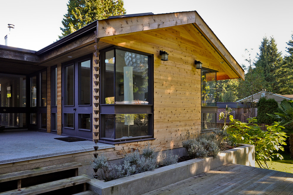 Photo of a medium sized modern two floor detached house in Vancouver with wood cladding.