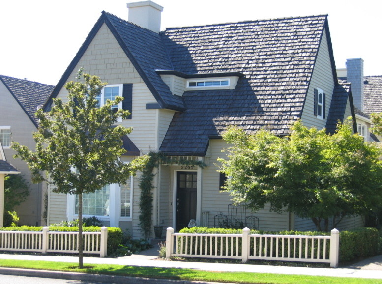 На фото: двухэтажный, деревянный, зеленый дом среднего размера в классическом стиле с двускатной крышей с