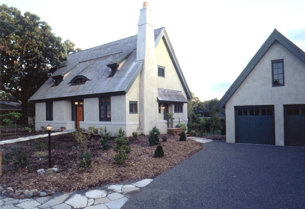 Foto de fachada de casa beige de estilo de casa de campo de tamaño medio de dos plantas con revestimiento de estuco, tejado a dos aguas y tejado de teja de madera