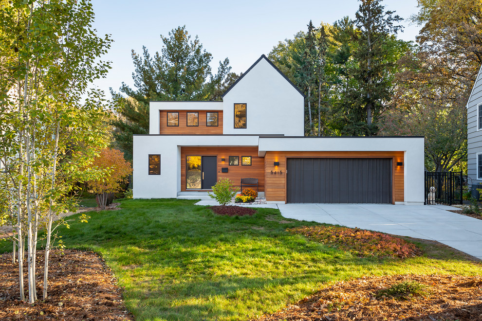 Cette image montre une façade de maison multicolore design à un étage avec un revêtement mixte et un toit à deux pans.
