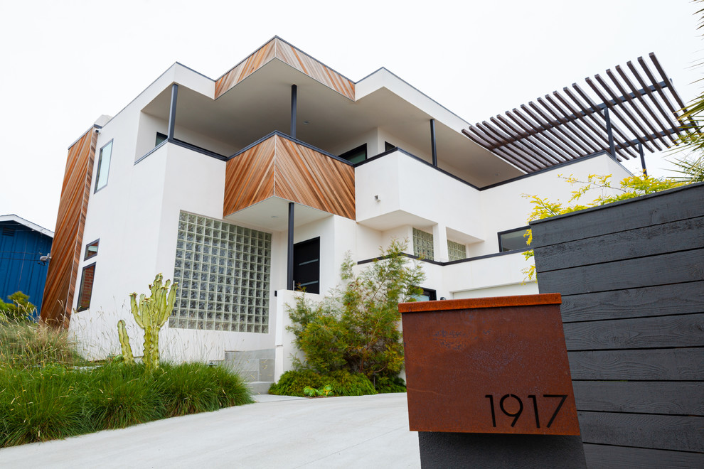 Стильный дизайн: большой, двухэтажный, белый частный загородный дом в современном стиле с облицовкой из цементной штукатурки, плоской крышей и зеленой крышей - последний тренд