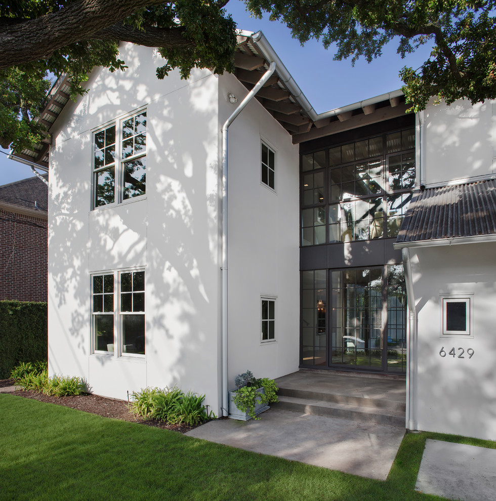 На фото: большой, двухэтажный, белый частный загородный дом в стиле неоклассика (современная классика) с двускатной крышей, облицовкой из цементной штукатурки и металлической крышей