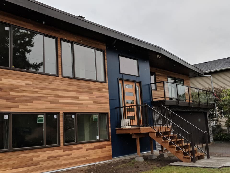 Large and blue modern two floor detached house in Seattle with mixed cladding and a flat roof.