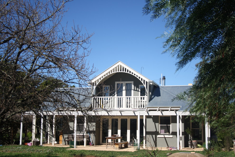 Imagen de fachada de casa gris tradicional de tamaño medio de dos plantas con revestimiento de ladrillo, tejado a dos aguas y tejado de metal
