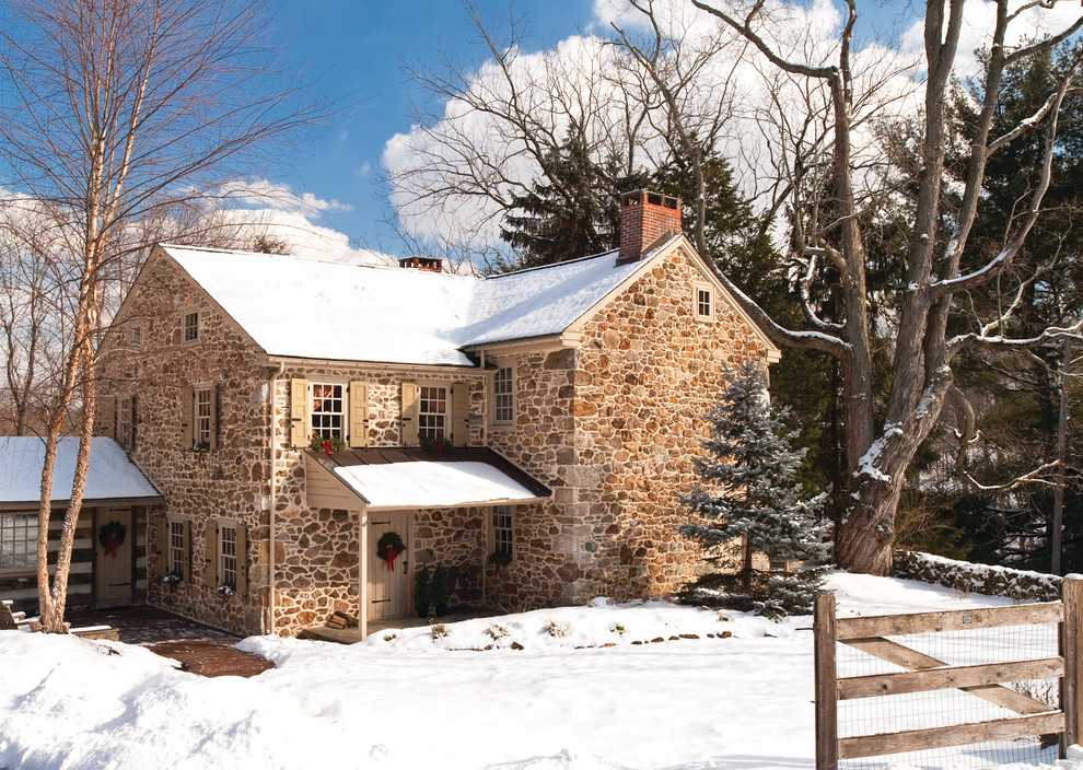 Farmhouse beige two-story stone gable roof photo in Philadelphia