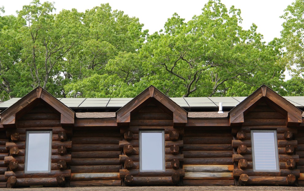 Cette image montre une façade de maison marron chalet en bois de taille moyenne et à un étage.