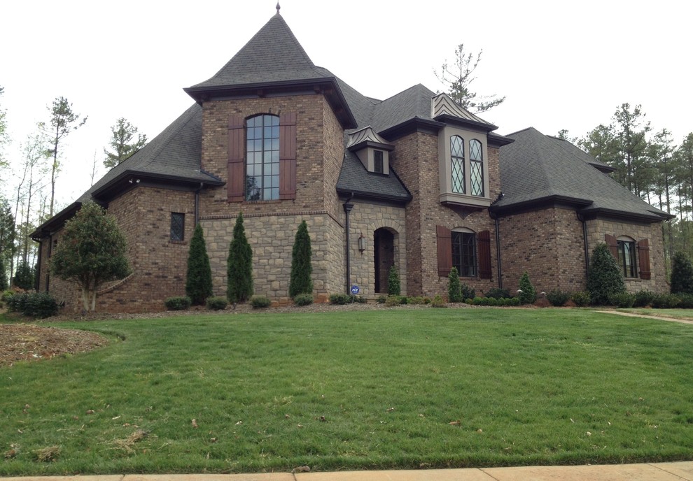 Mid-sized traditional brown two-story mixed siding gable roof idea in Charlotte