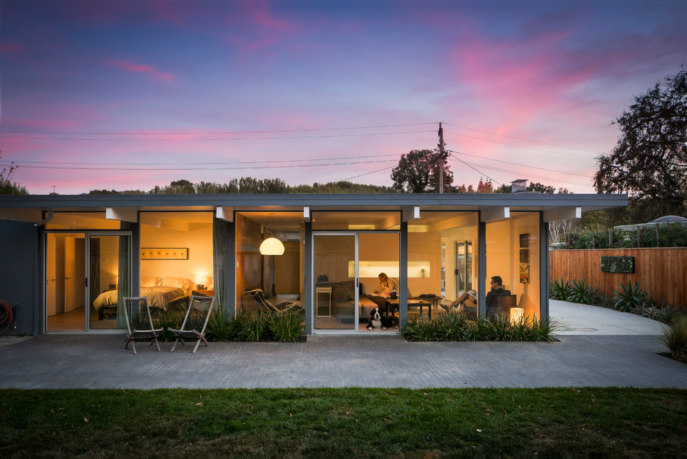 Foto della villa grigia moderna a un piano di medie dimensioni con tetto piano, rivestimento in legno, tetto grigio e pannelli sovrapposti