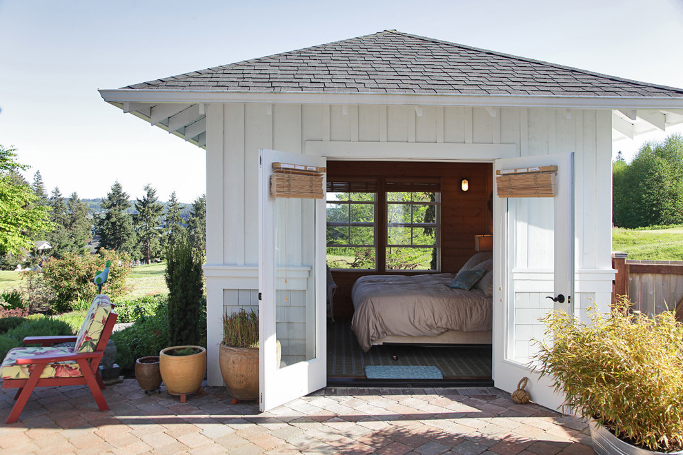 This is an example of a small nautical bungalow house exterior in Seattle with wood cladding and a hip roof.