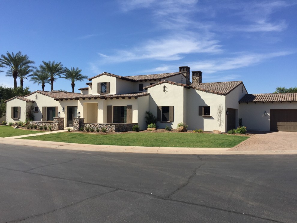 Large southwest beige two-story concrete exterior home photo in Phoenix with a shingle roof