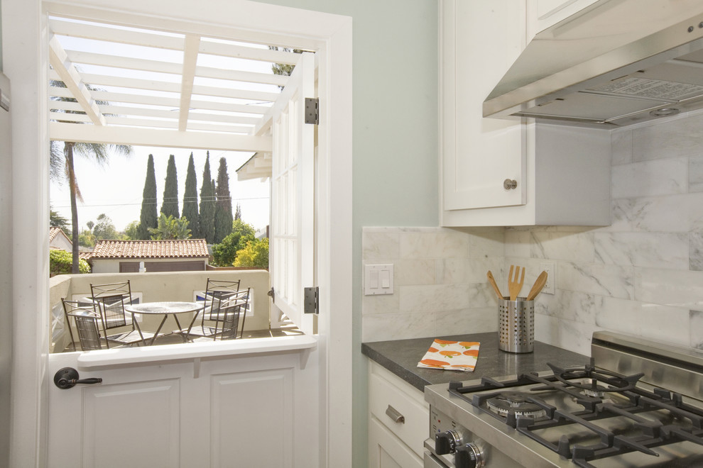 Inspiration for a timeless kitchen remodel in San Diego with shaker cabinets, white cabinets, granite countertops, white backsplash, stone tile backsplash and stainless steel appliances