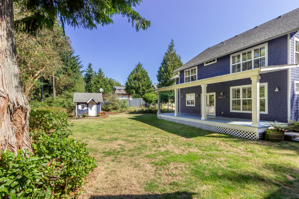 Inspiration for a large timeless blue two-story wood exterior home remodel in Seattle with a clipped gable roof